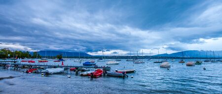 Storm clouds at dawn over a small bay at Creux de Genthod, Lake Geneva, Switzerland の写真素材