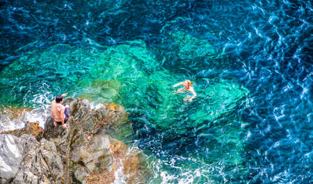Manarola, Cinque Terre, Italy. August 6, 2012. Tourist swimming in the clear, truquoise water of Mediterranean sea, of the Ligurian coast, Italy.のeditorial素材