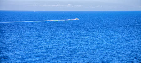 Boat speeding across the Mediterranean sea off the Liguarian coast, Italyの写真素材