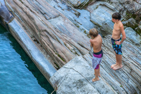 Lavertezzo, Verzasca Valley, Ticino, Switzerland. September 15th 2012. Two boys waiting to dive into...