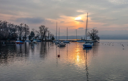Boats at a small in Lake Geneva and the morning sunrise 