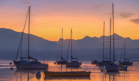 Sunrise and sailboats at a small bay in lake Geneva, Switzerlandの写真素材