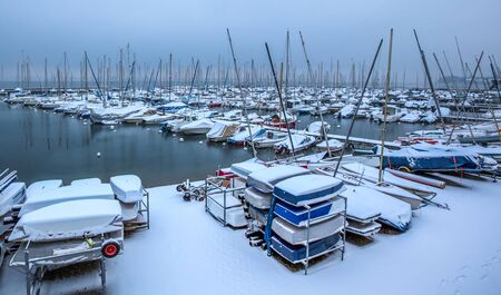Boats at a Swiss Marina in Versoix covered with snows during winter の写真素材