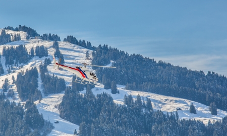 A helicopter flying in Swiss mountainの写真素材