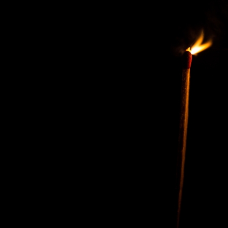 Burning match with a black backgroundの写真素材