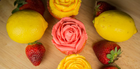 Cupcakes, lemon and strawberry on a pastry board 