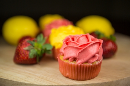 Cupcakes, lemon and strawberry on a pastry board の写真素材
