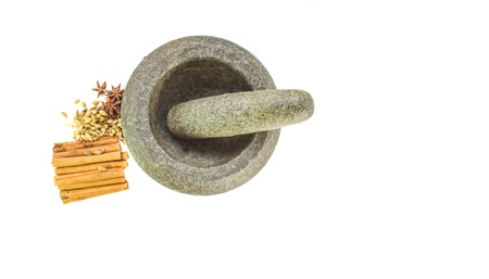A group of cardamom, star anise, cinnamon stick spices with a stone mortar の写真素材