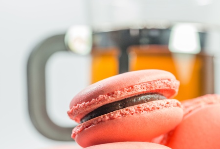 A group of pink French macarons and a mug of teaの写真素材