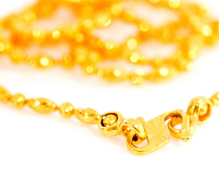 A gold necklace over white background