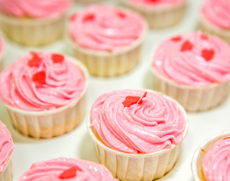 Pink cupcakes with heart shape toppingsの写真素材