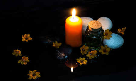 Dim light spa massage set with zen stones, candle and massage oilの写真素材