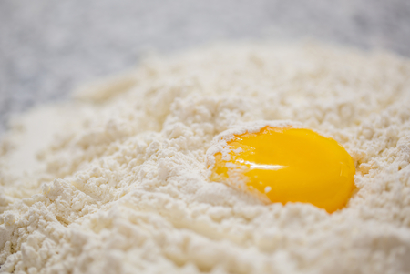 Flour and egg yolk  on a granite counter surface の写真素材