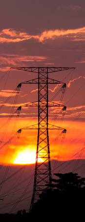 Sunset over the horizon with electric pylonsの写真素材