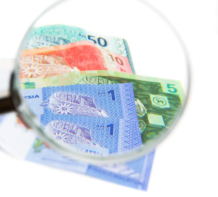 Malaysia bank notes money with magnifying glass