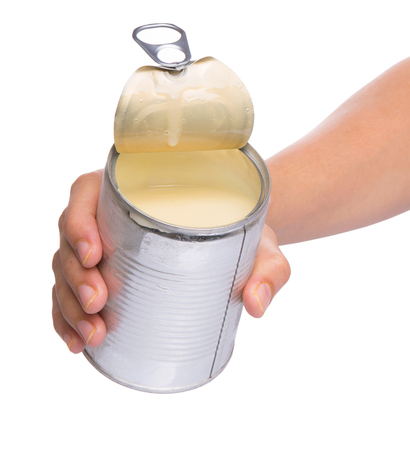 Female hand holding a tin can of condensed milkの写真素材