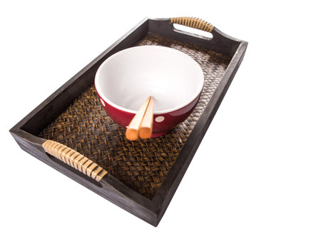 A pair of chopstick and and a bowl on a woven trayの写真素材