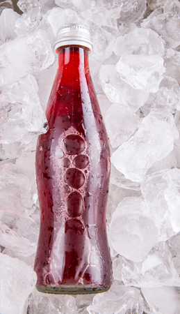 Bottled grape juice cooled with ice cubesの写真素材