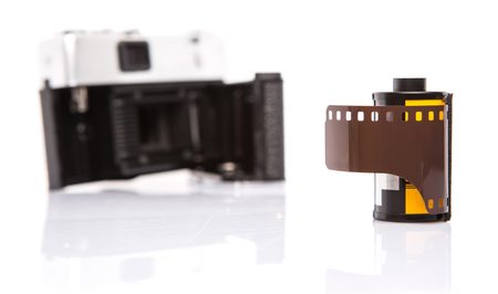 Old retro analog camera with new film roll over white backgroundの写真素材