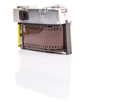 Old retro analog camera with new film roll over white backgroundの写真素材