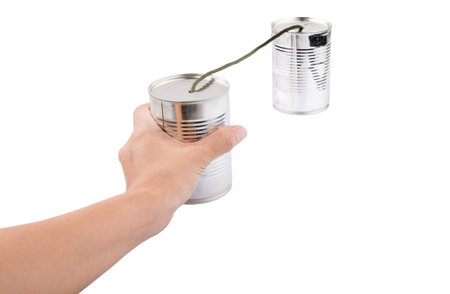 Female hand holding tin can telephone over white background