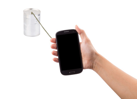 Concept Image of female hand holding a smart phone connected to a tin can の写真素材