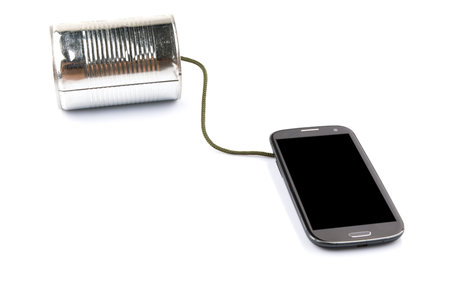 Concept image of a smart phone connected to a tin can phoneの写真素材