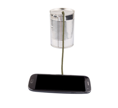 Concept image of a smart phone connected to a tin can phoneの写真素材