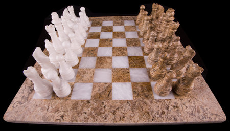 Stone made chess set on black background