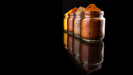Mix powdered spices in glass container over black backgroundの写真素材