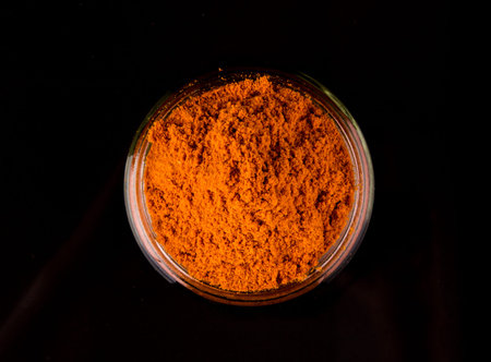 Powdered curry spices over black background