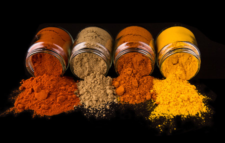 Mix powdered spices in glass container over black backgroundの写真素材