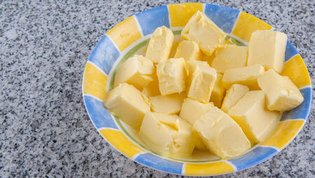 A group of melting butter in a bowl over granite surfaceの写真素材