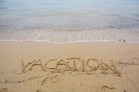 The VACATION word written on beach sand の写真素材