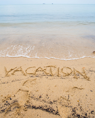 The VACATION word written on beach sandの写真素材