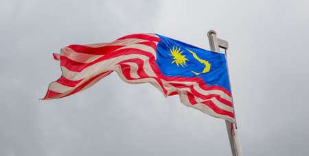 A Malaysian flag over a stormy cloud skyの写真素材