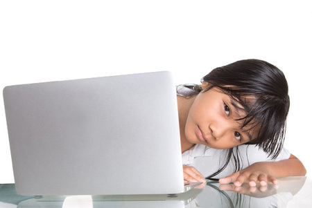 Young Asian Malay school girl in school uniform with a laptop 