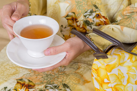 Female hands holding a cup of teaの写真素材