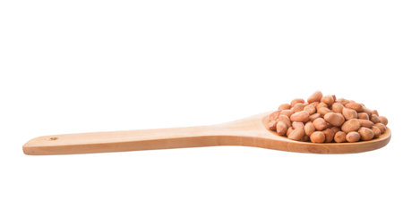 Ground nut or peanut on wooden spoon over white backgroundの写真素材