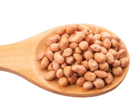 Ground nut or peanut on wooden spoon over white background