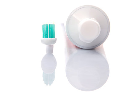 Toothbrush and toothpaste over white background
