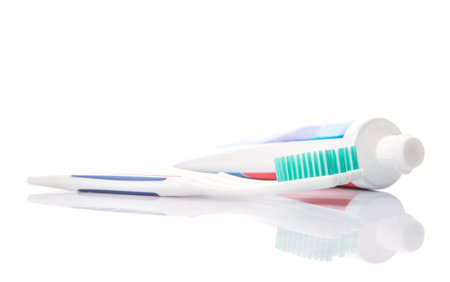 Toothbrush and toothpaste over white background