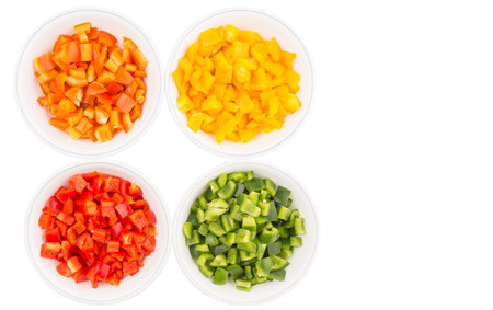 Colorful chopped capsicums in white bowls over white backgroundの写真素材