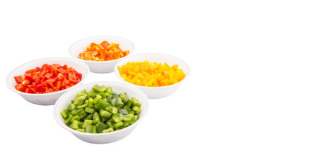 Colorful chopped capsicums in white bowls over white backgroundの写真素材
