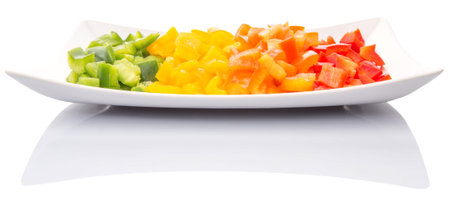Colorful chopped capsicums in a plate over white backgroundの写真素材