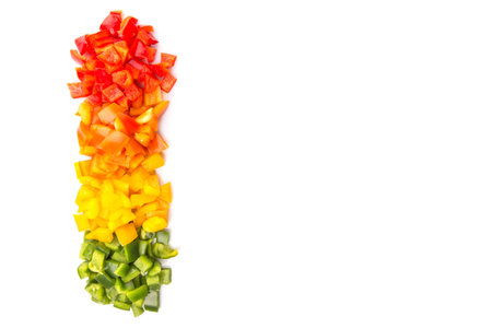 Chopped colorful capsicums over white background