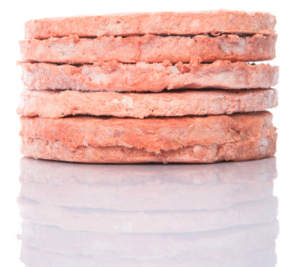 Frozen raw hamburger beef meat over white backgroundの写真素材