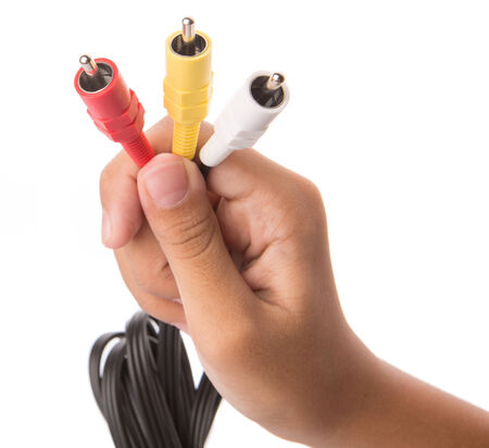 Female teenage hand holding audio and video cinch connectorの写真素材