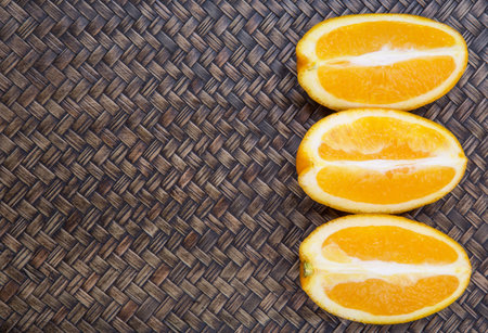 Slice of orange fruit over wicker background 
