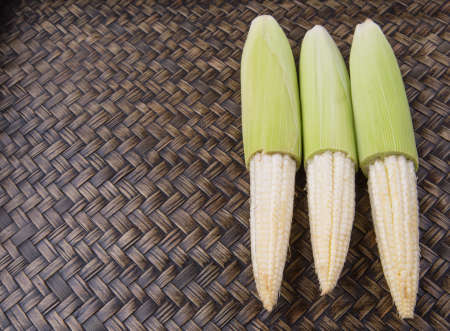 Baby corns over wicker backgroundの写真素材